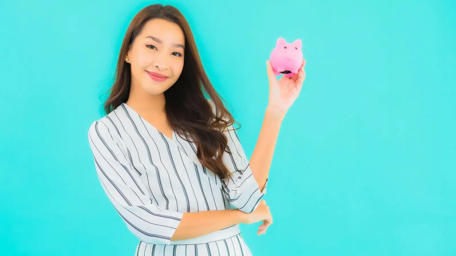 investing in your startup business - young woman smiling with a piggy bank