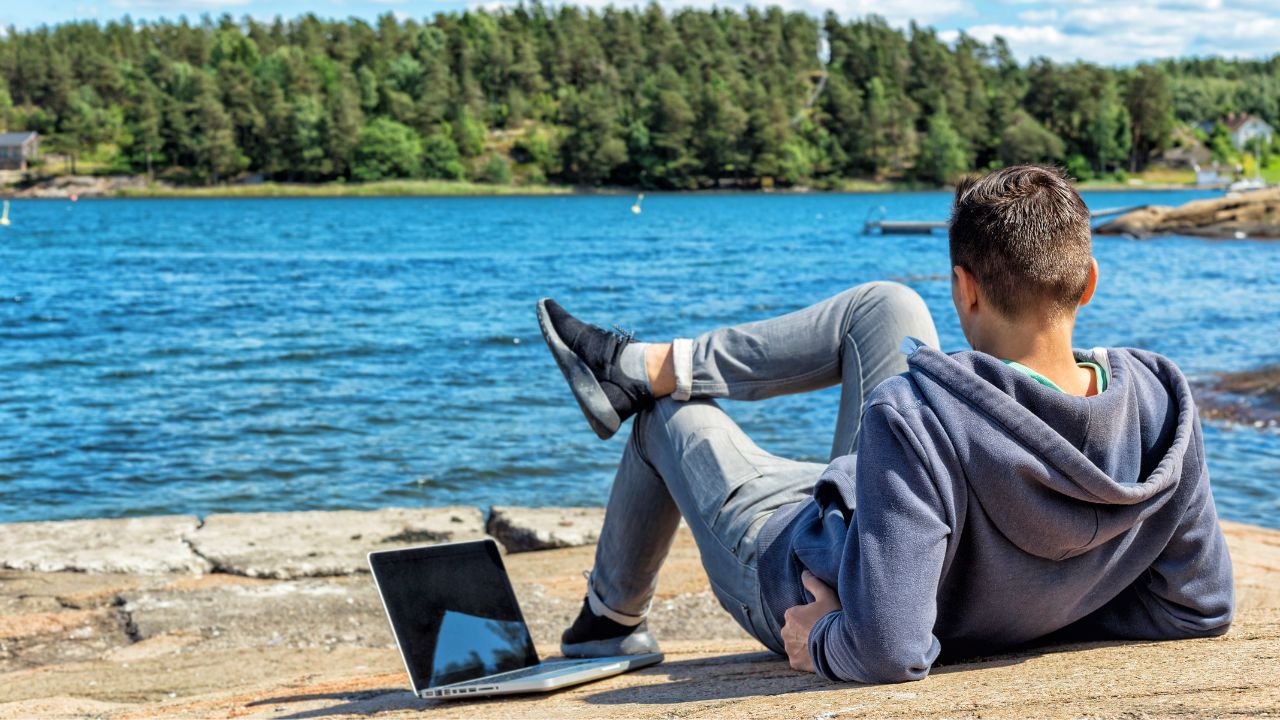 Man with laptop on colorful beach of island