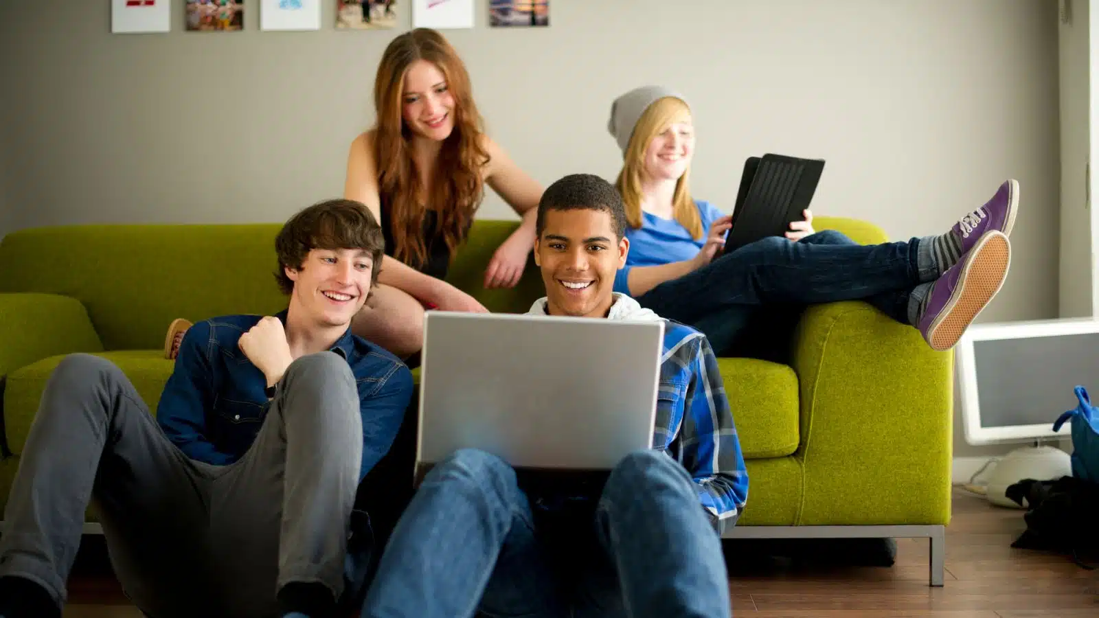 a group of teenagers on laptops on the couch