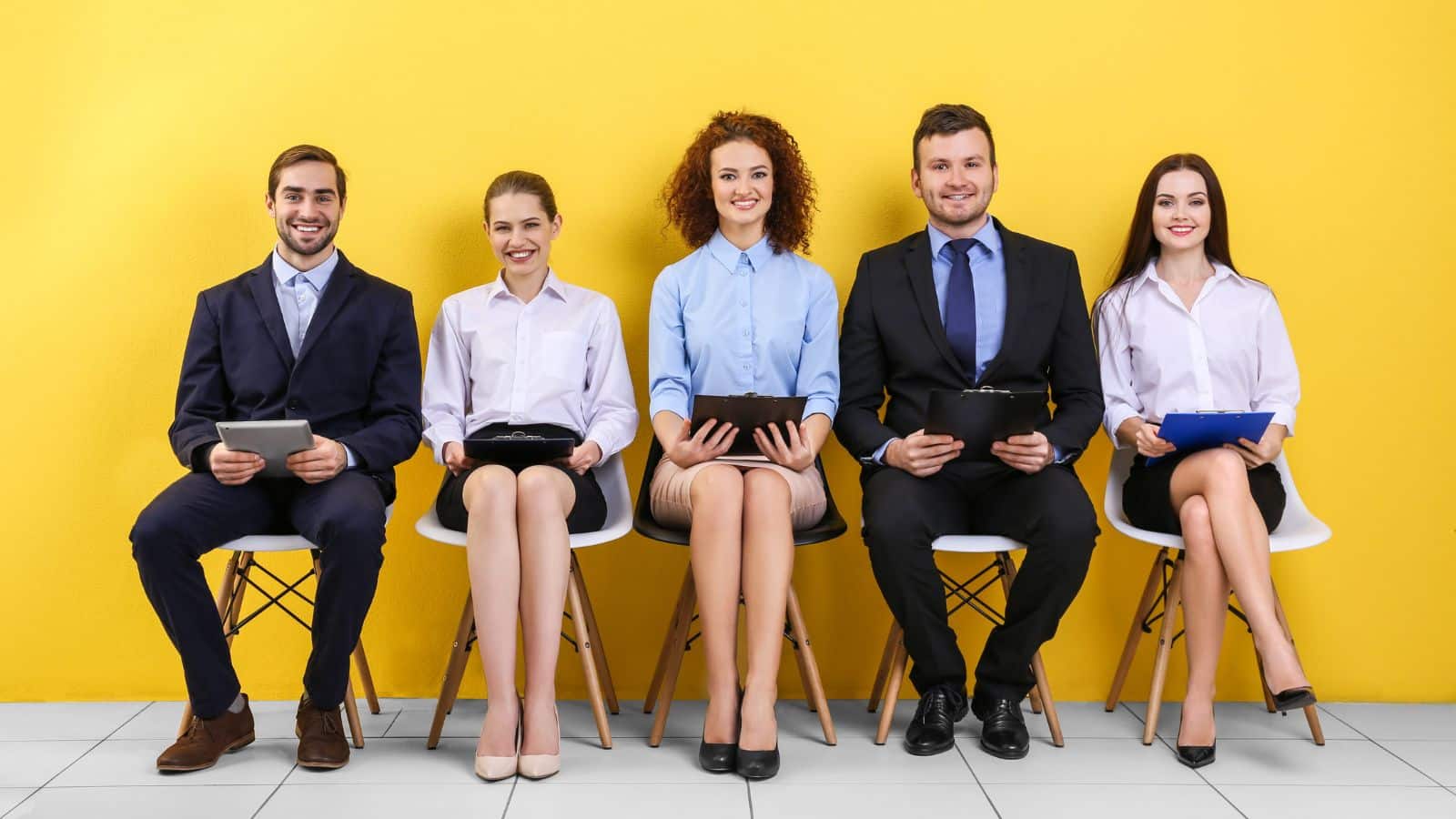 smiling group of people waiting for a job interview with a yellow background