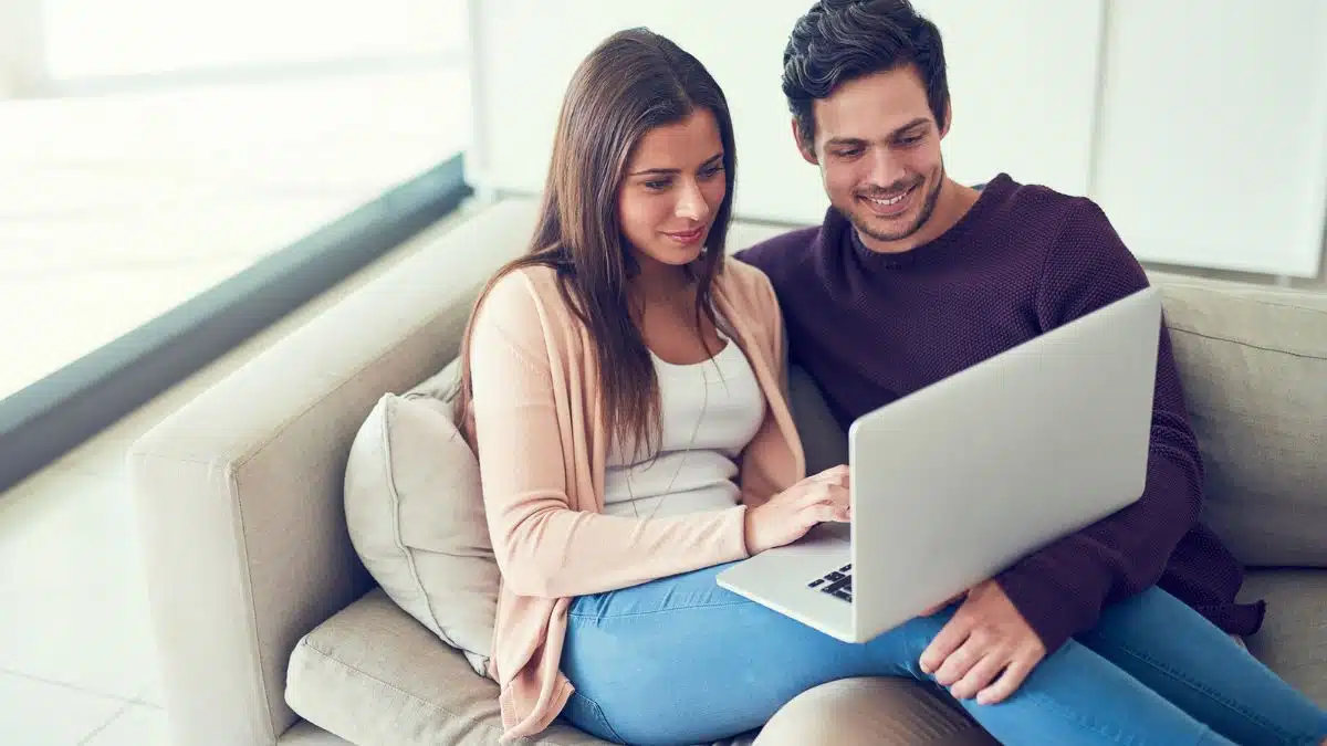 couple with a laptop on the couch