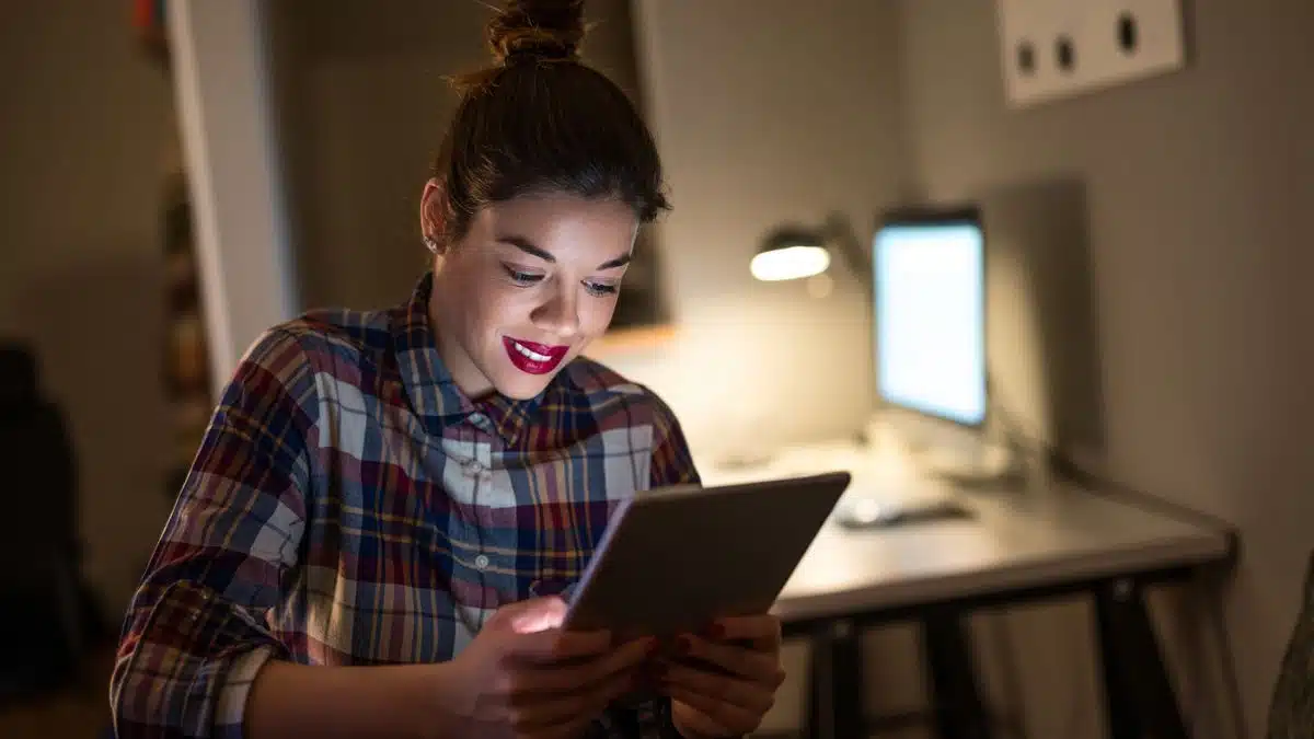 happy woman working at night on a tablet