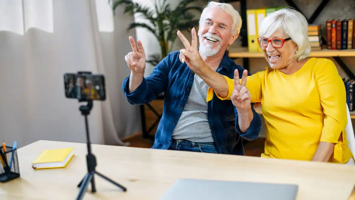 mature couple recording a video giving peace sign