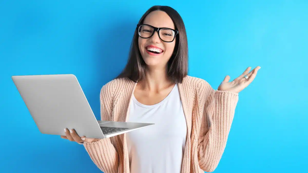 Happy young woman holding a laptop.