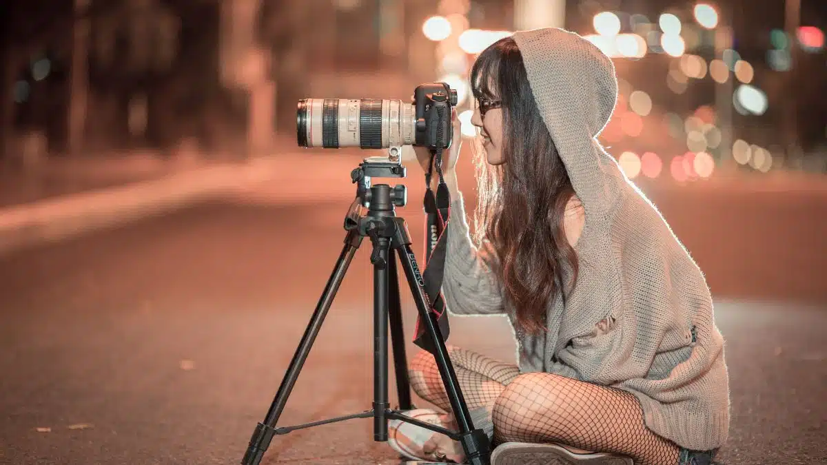 young woman Photographer at night setting up a shot