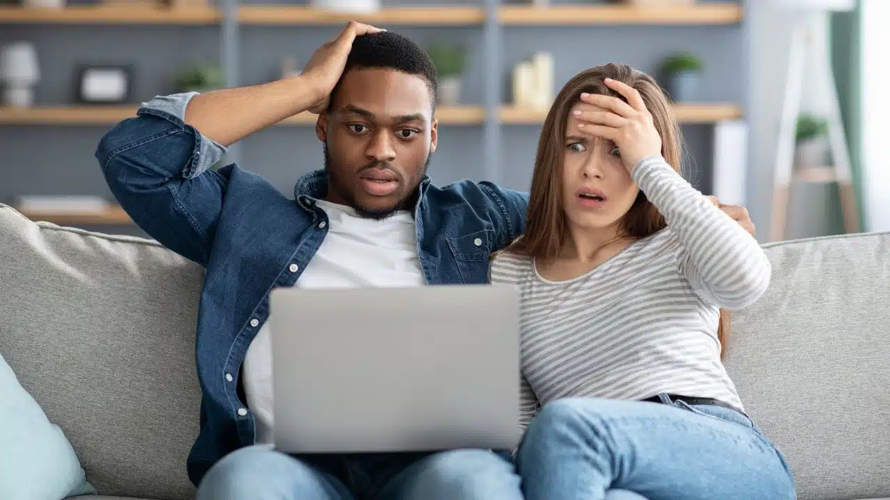 shocked couple getting bad news on their laptop