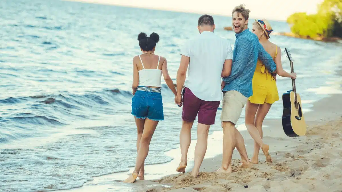 friends on a beach walking along the water