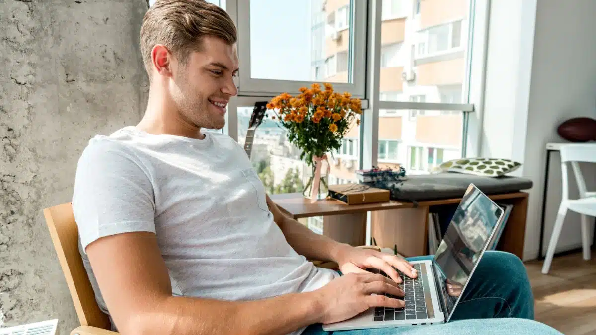 happy man working on laptop at home