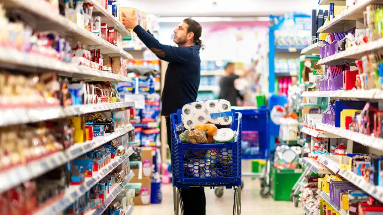 man grocery shopping with full cart