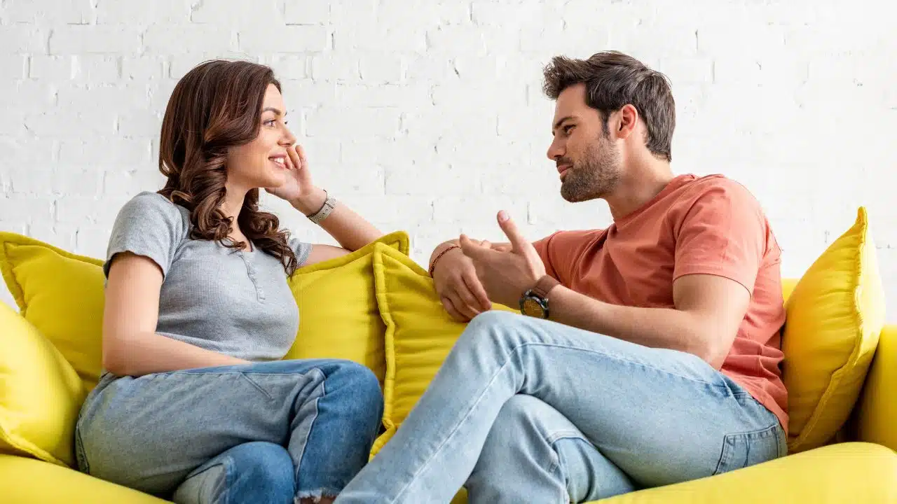 happy couple talking at home on the couch