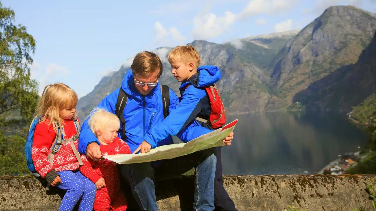 father and kids outdoors with map