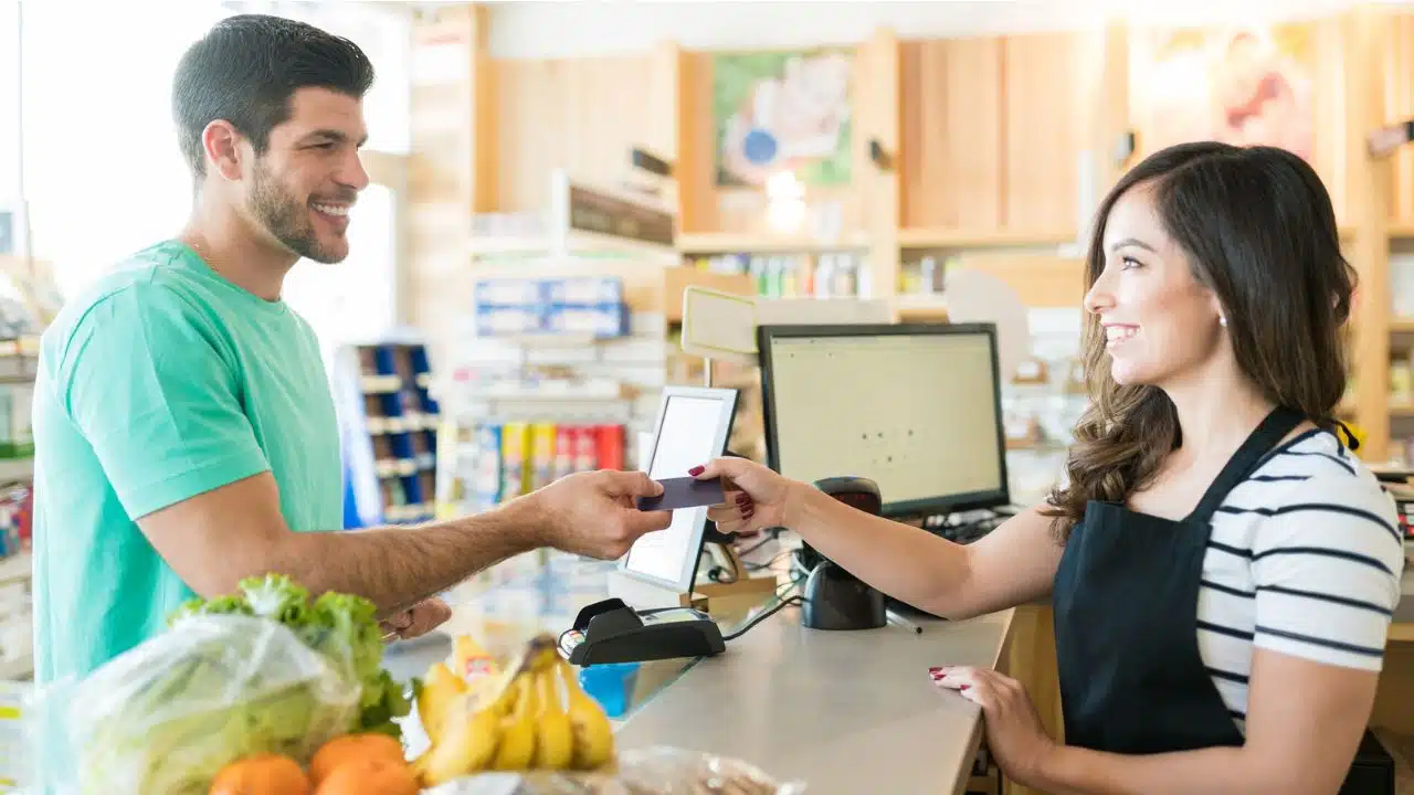 man paying at the grocery store checkout