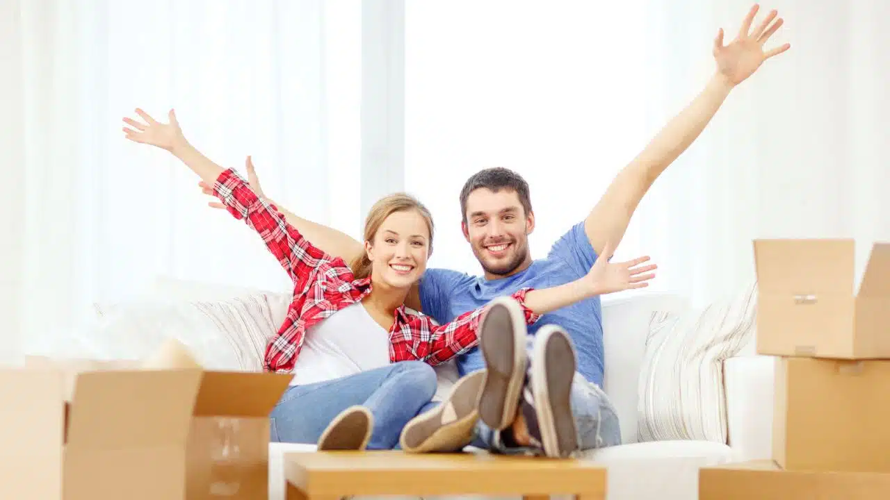 happy couple with moving boxes in new home