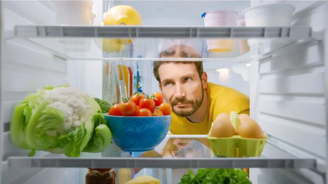 man looking in fridge disappointed