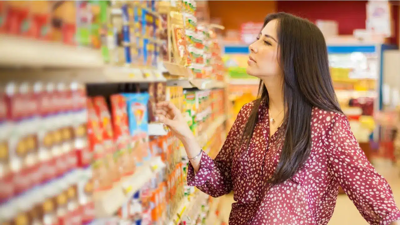woman looking at grocery shelf food labels
