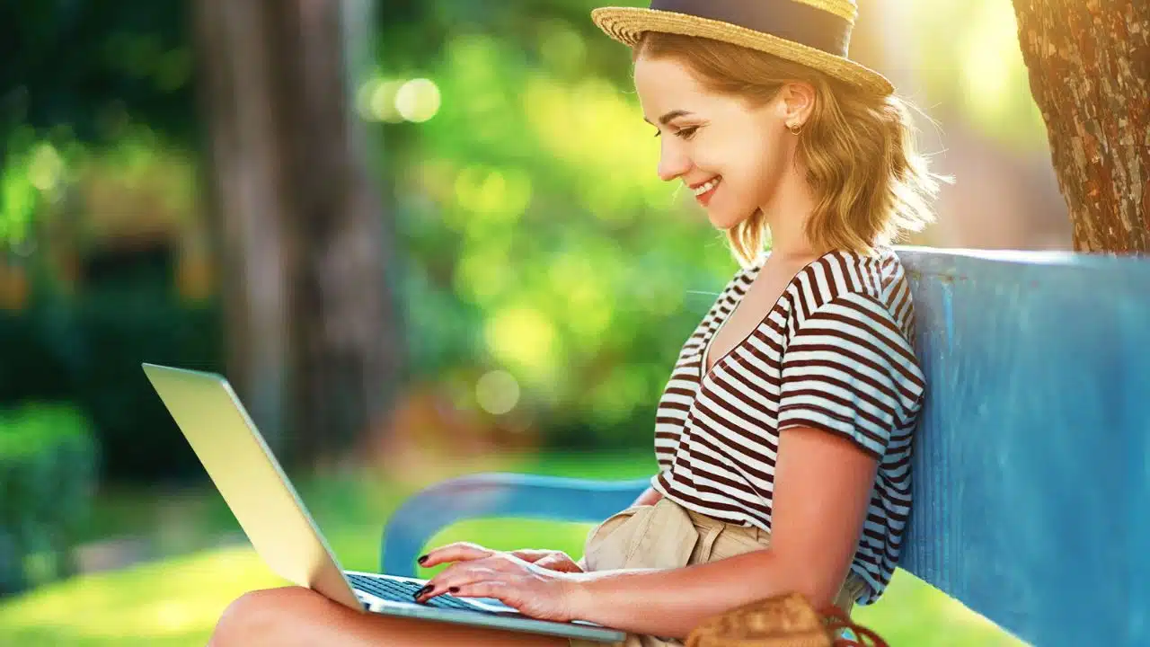 woman with laptop on park bench