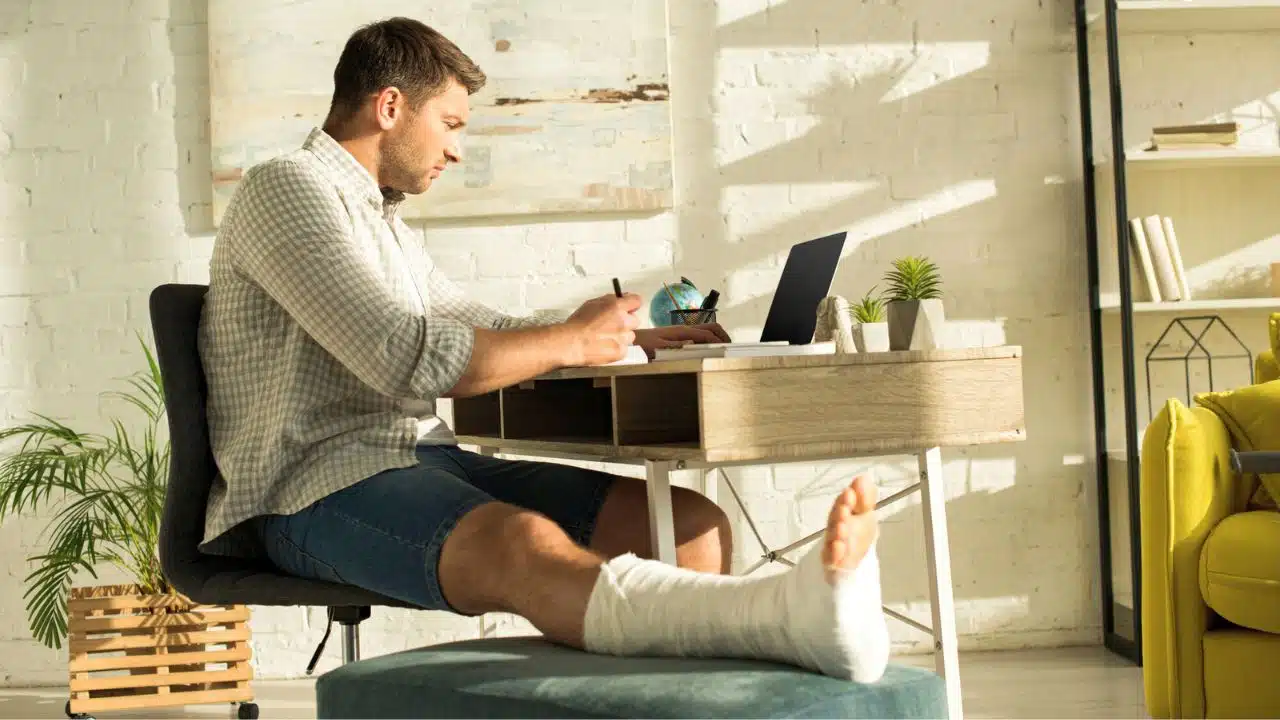 man with broken leg working from home