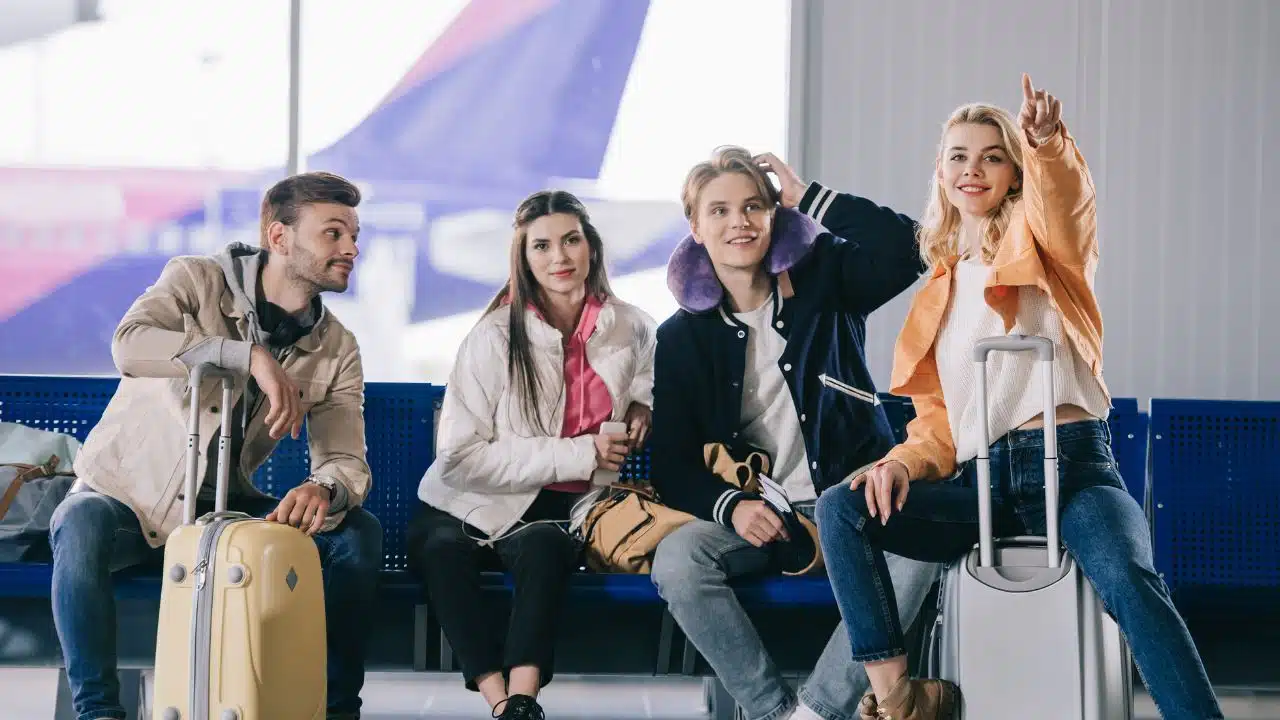 young people travelling at airport with luggage
