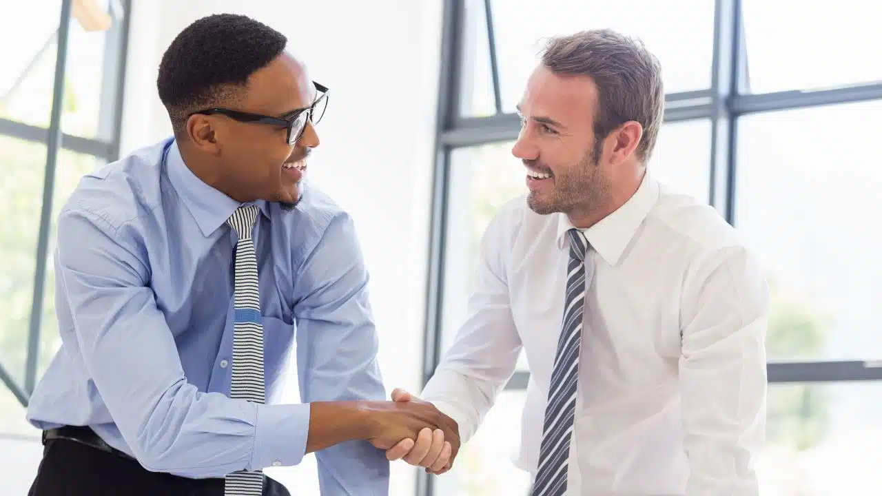 Businessmen shaking hands in office