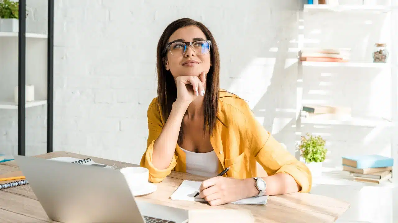 working woman happily thinking at her desk