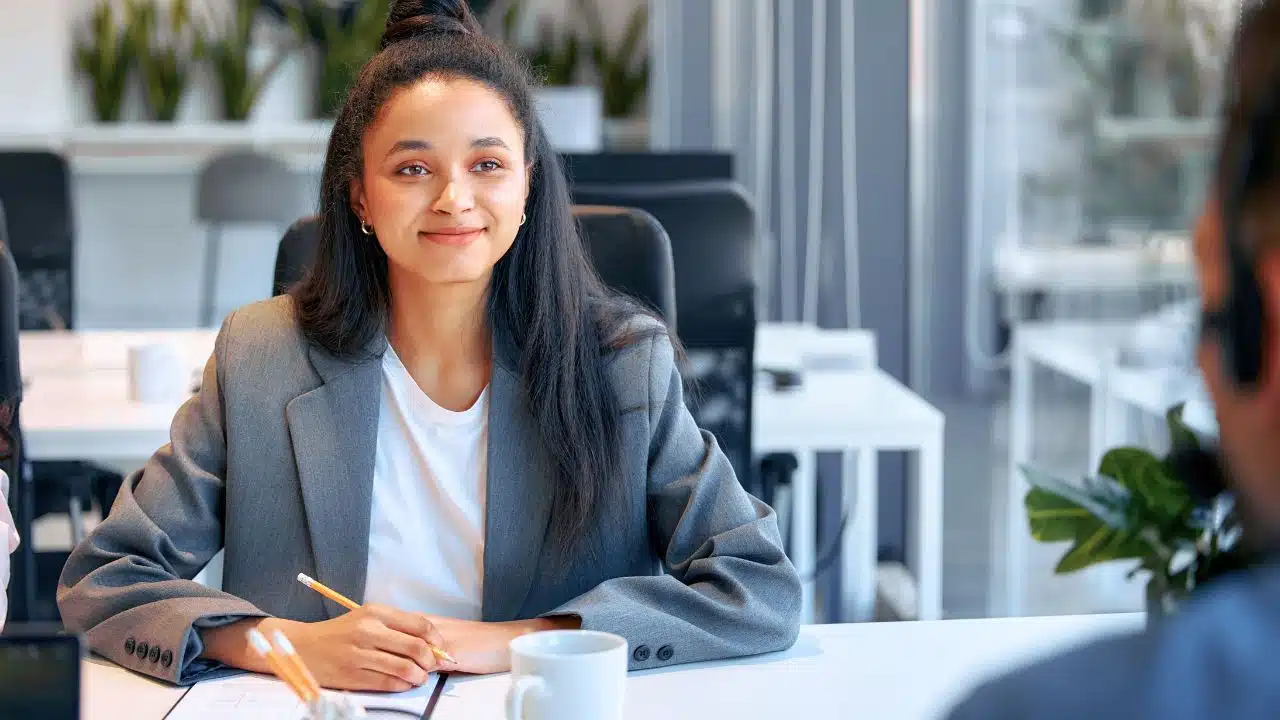 smiling young professional taking notes in meeting