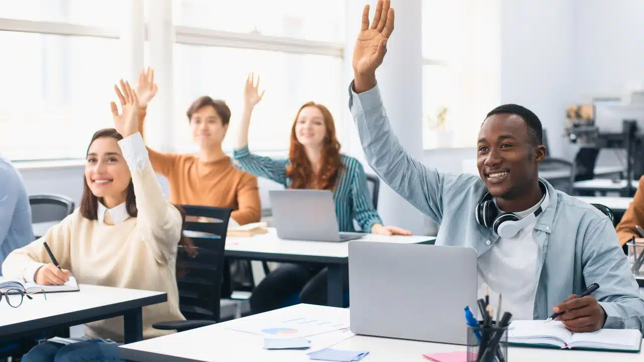 students raising hands in small class