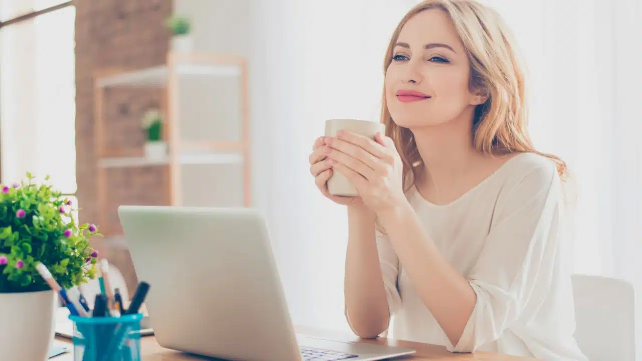 woman calmly enjoying coffee break at desk