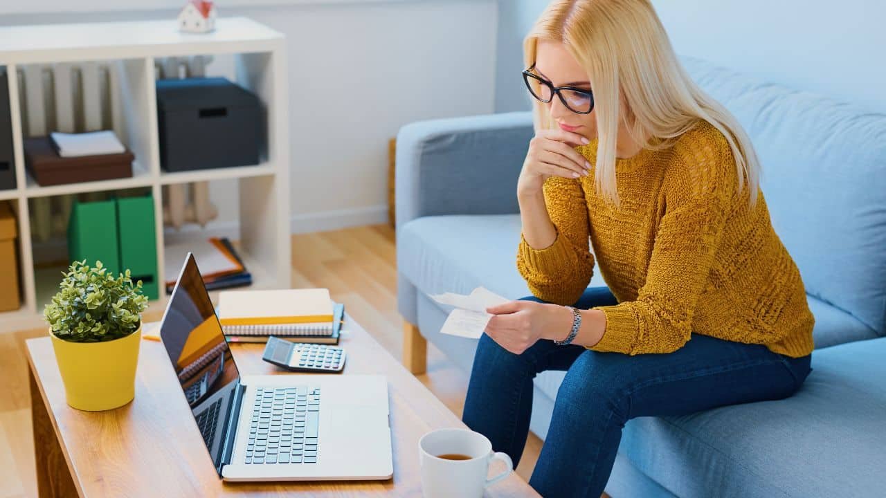 woman looking at receipts at home