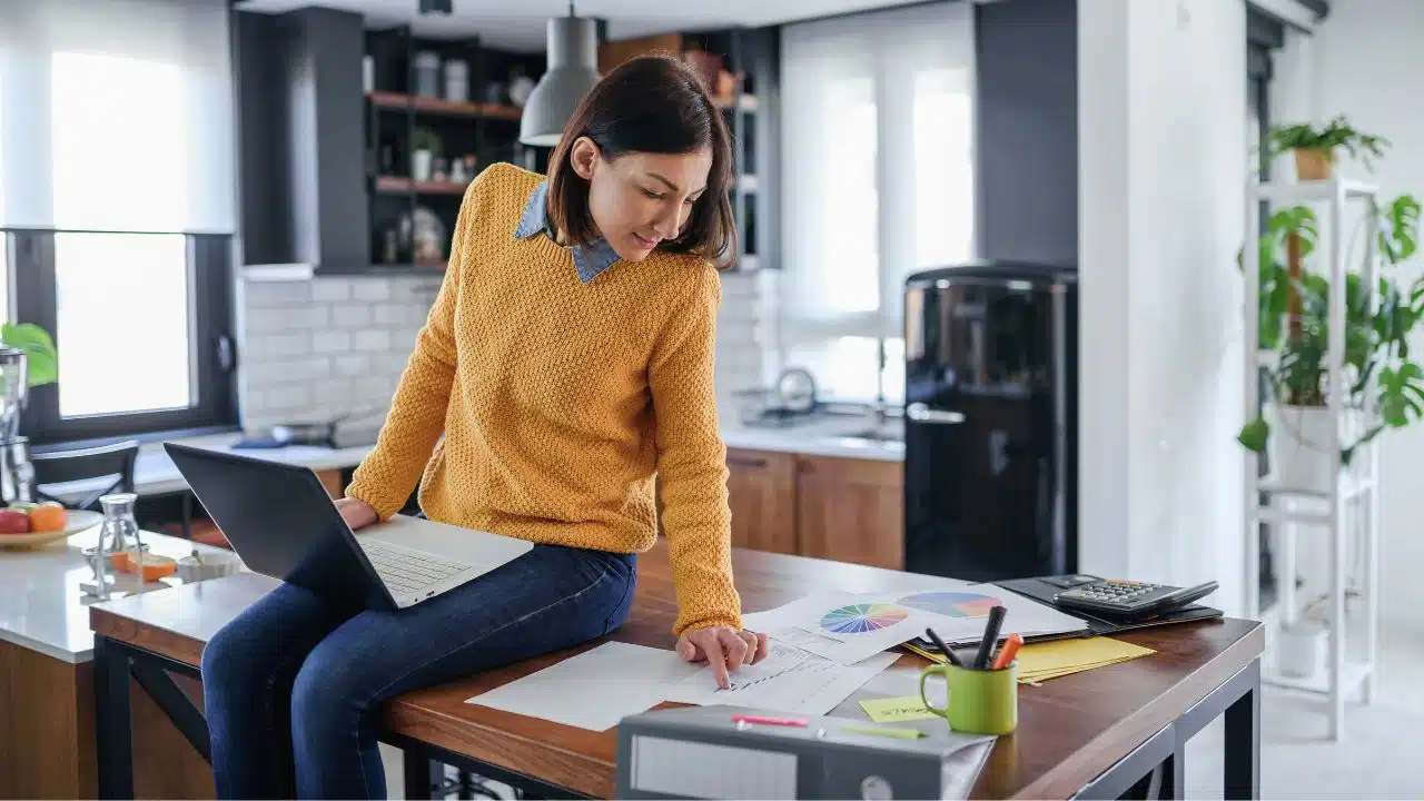 woman sitting on kitchen table working from home