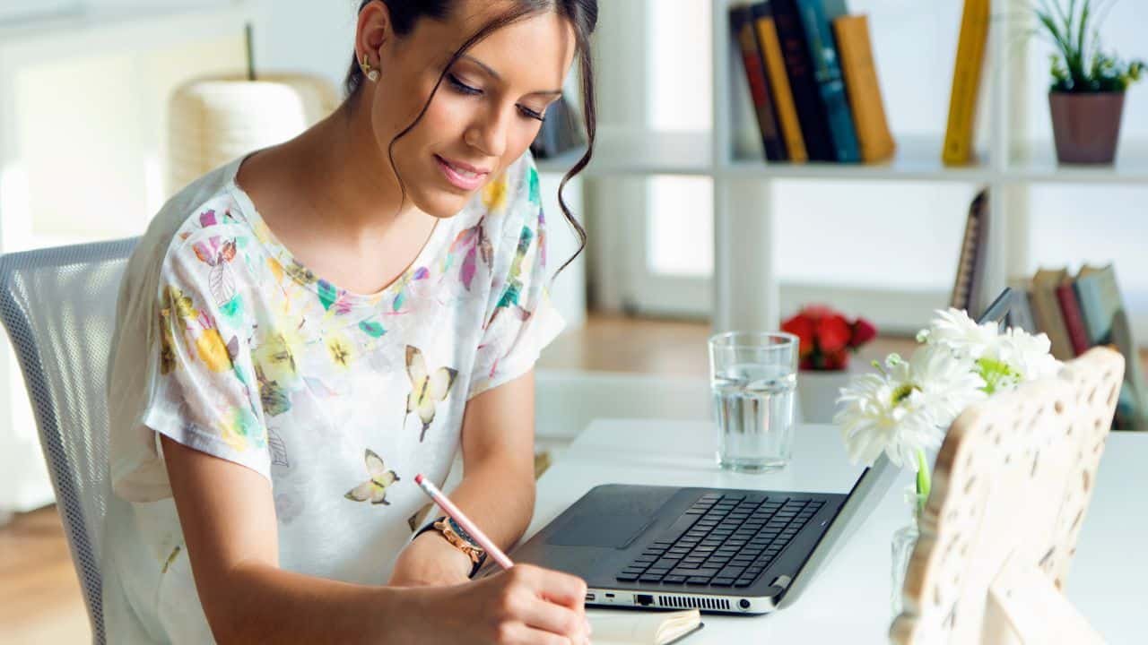 woman writing in notebook at her desk