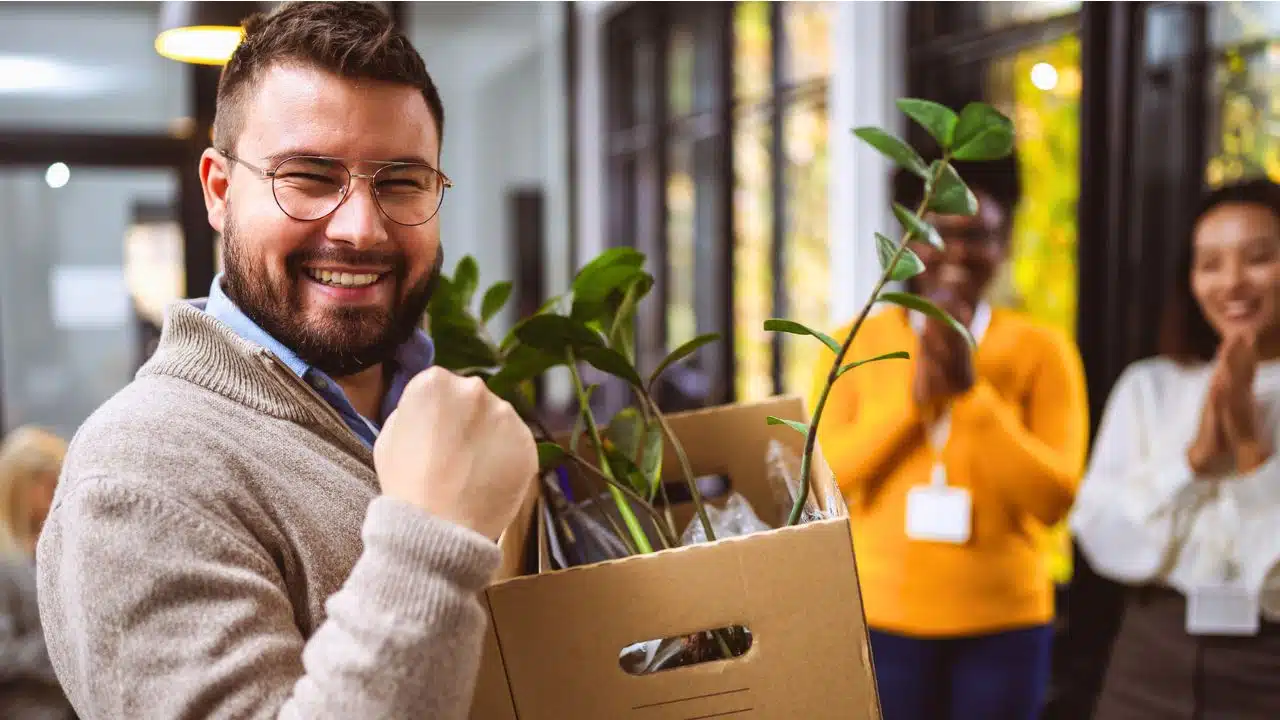 Business team meets an eager new employee with box of office supplies