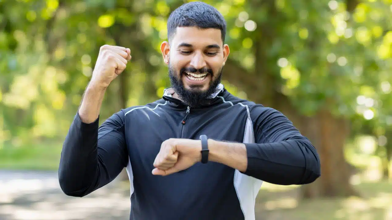 Motivated athlete checking fitness tracker after a run 