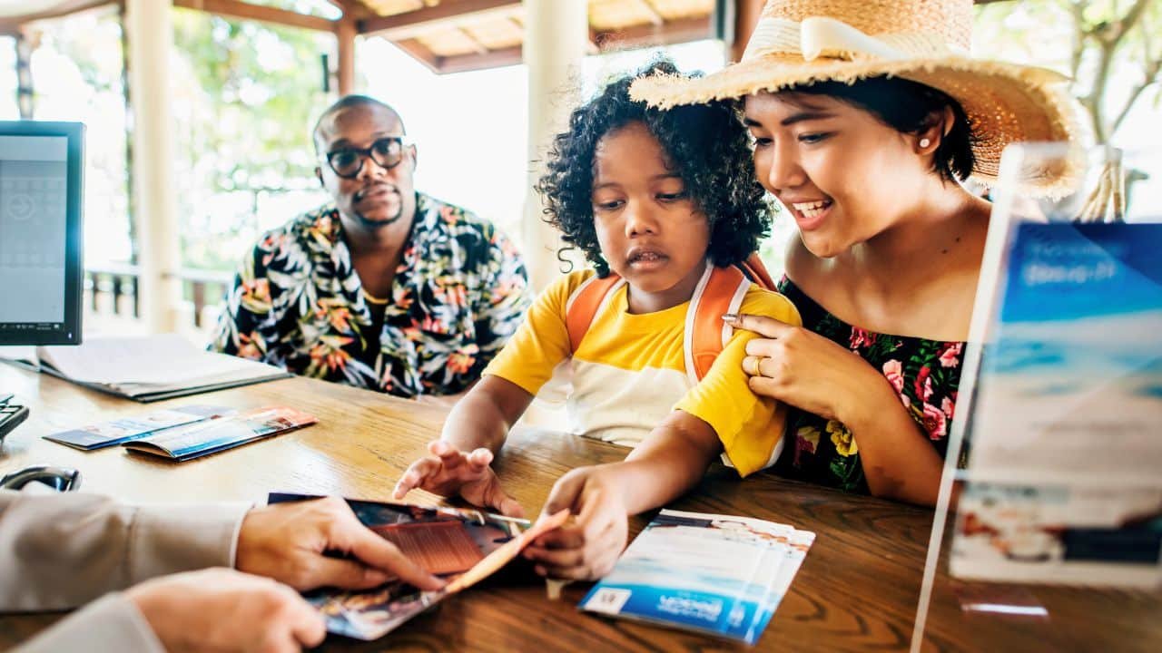 family checking into hotel looking at pamphlets
