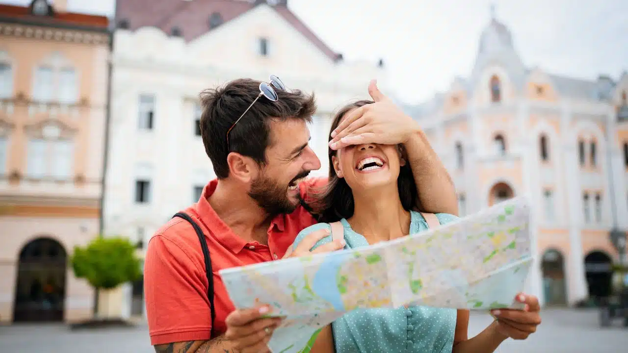 laughing couple with map on vacation