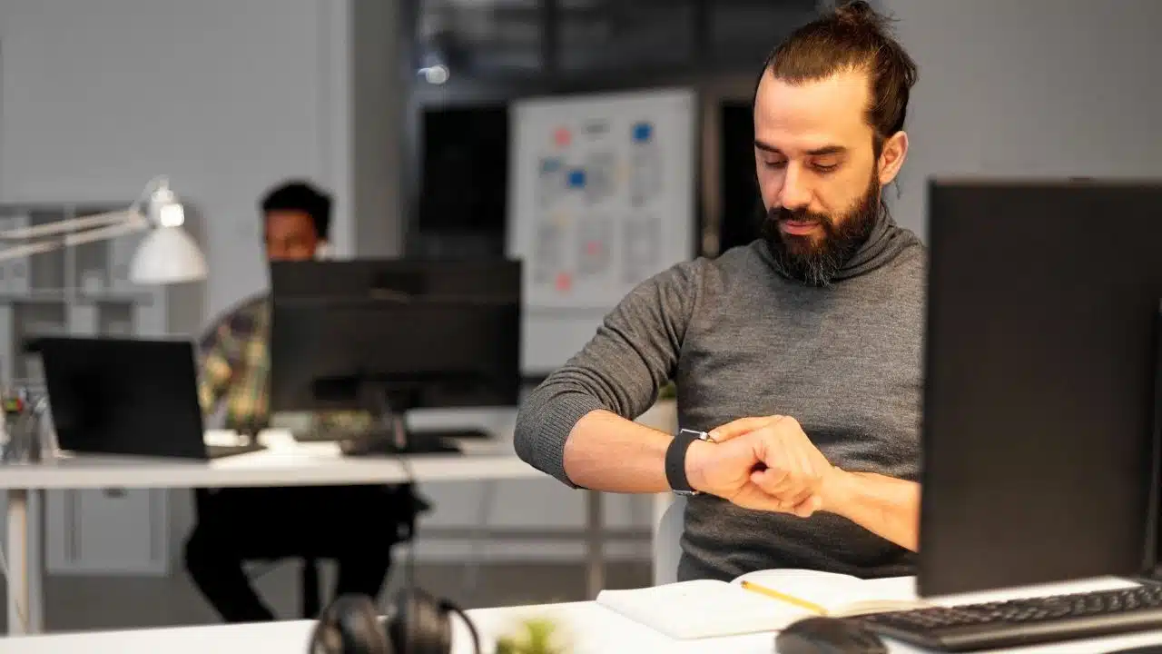 man with smartwatch at night office 