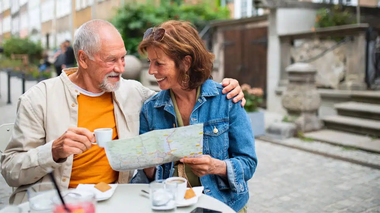 mature couple having breakfast on vacation with map