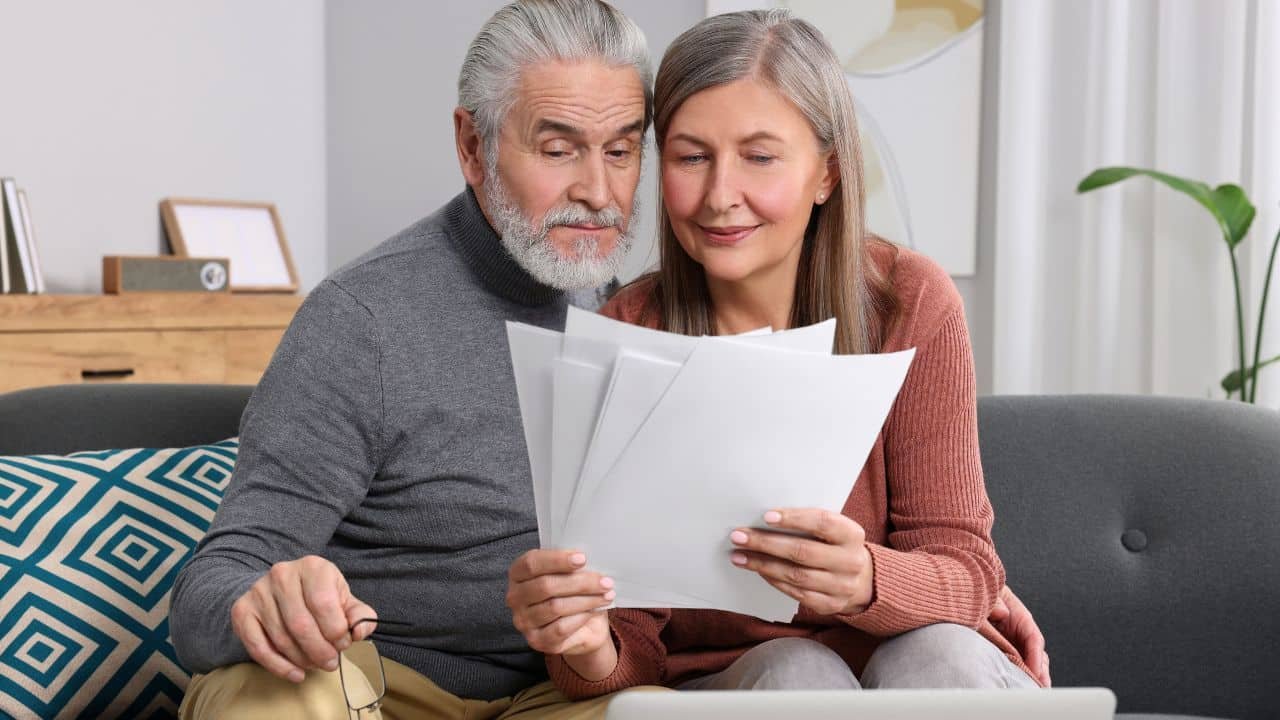 mature couple looking at paperwork at home