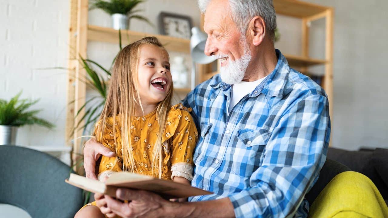grandfather reading book to granddaughter