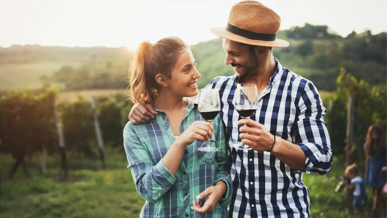 couple in vineyard with wine