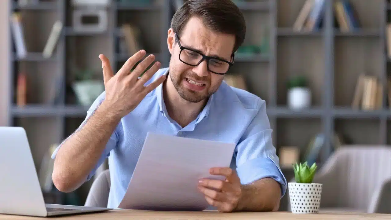 frustrated businessman looking at paperwork