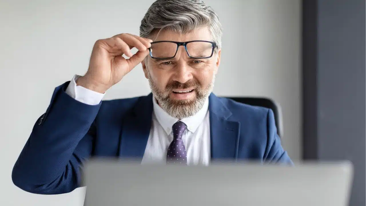 puzzled businessman looking at laptop