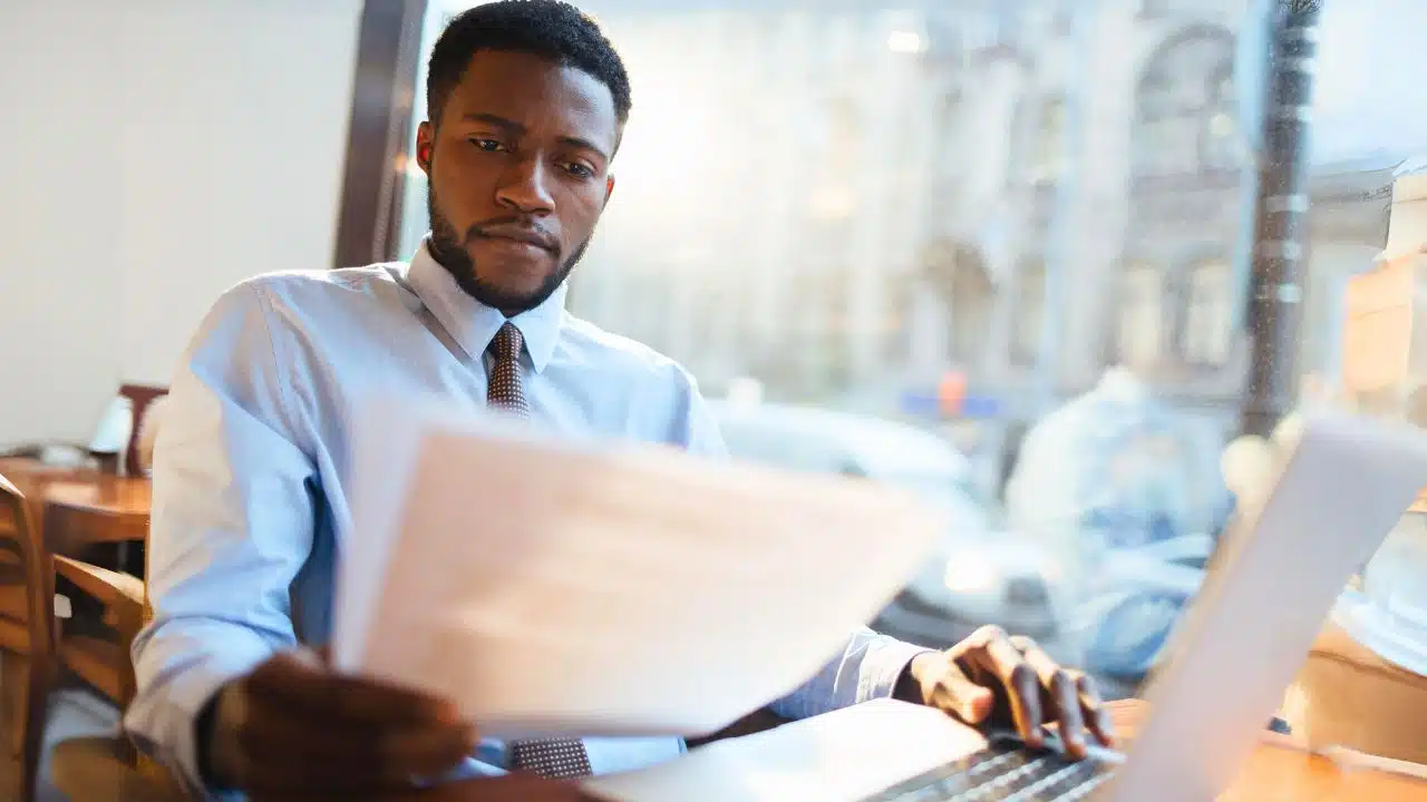 young man with document and laptop