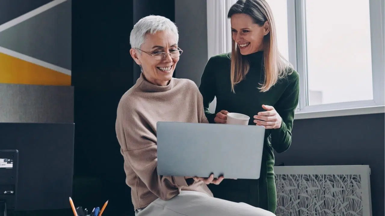 coworkers laughing with laptop