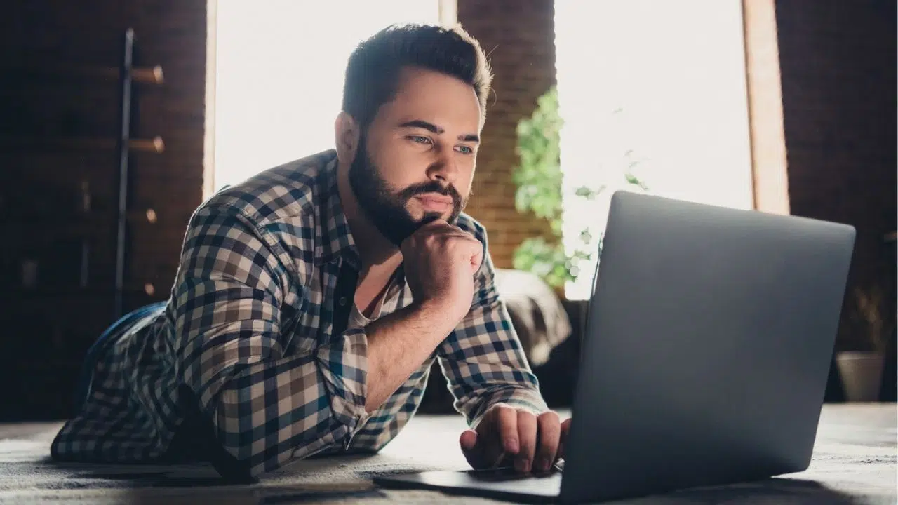 man laying on floor with laptop