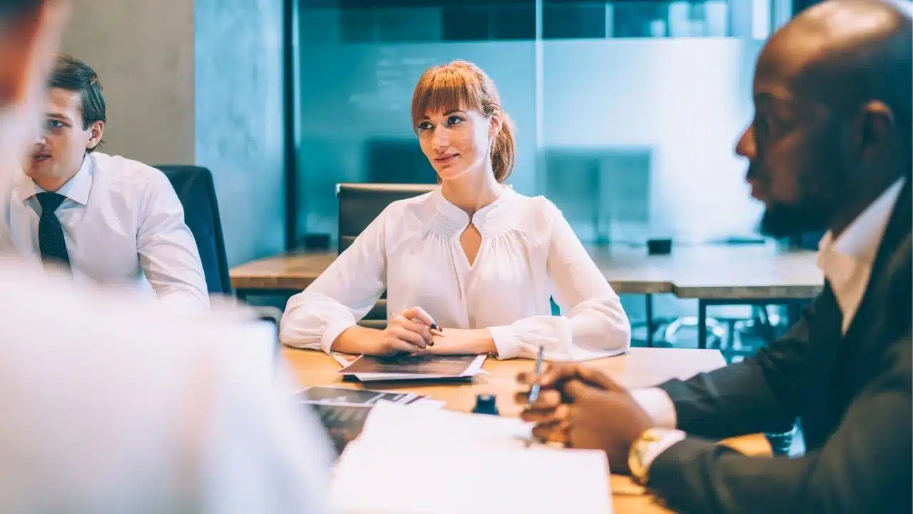 woman in work meeting listening to coworkers