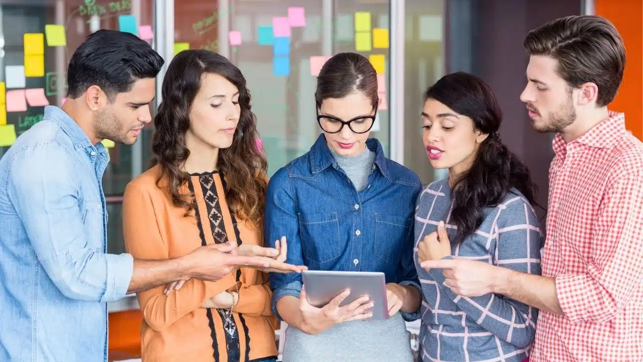 young coworkers problem solving, looking something on a tablet