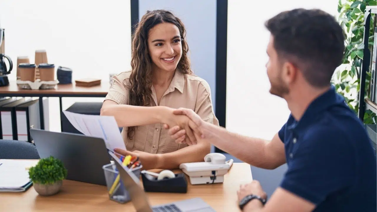 young professionals shaking hands in meeting